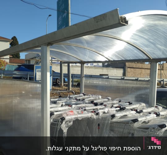 עגלות קניות עטופות בניילון מתחת לסככה שקופה